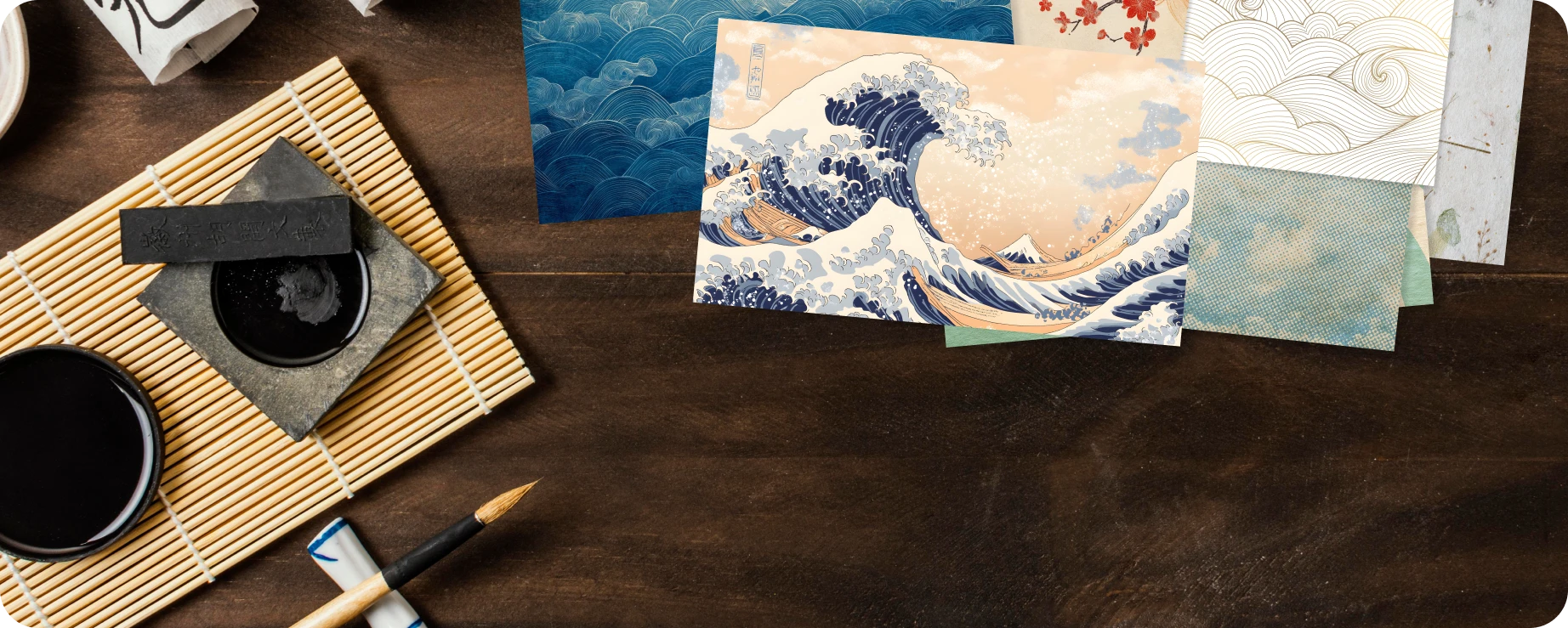Envelopes and papers bearing Japanese wave and cloud motifs, laid on a wooden desk with ink and brush